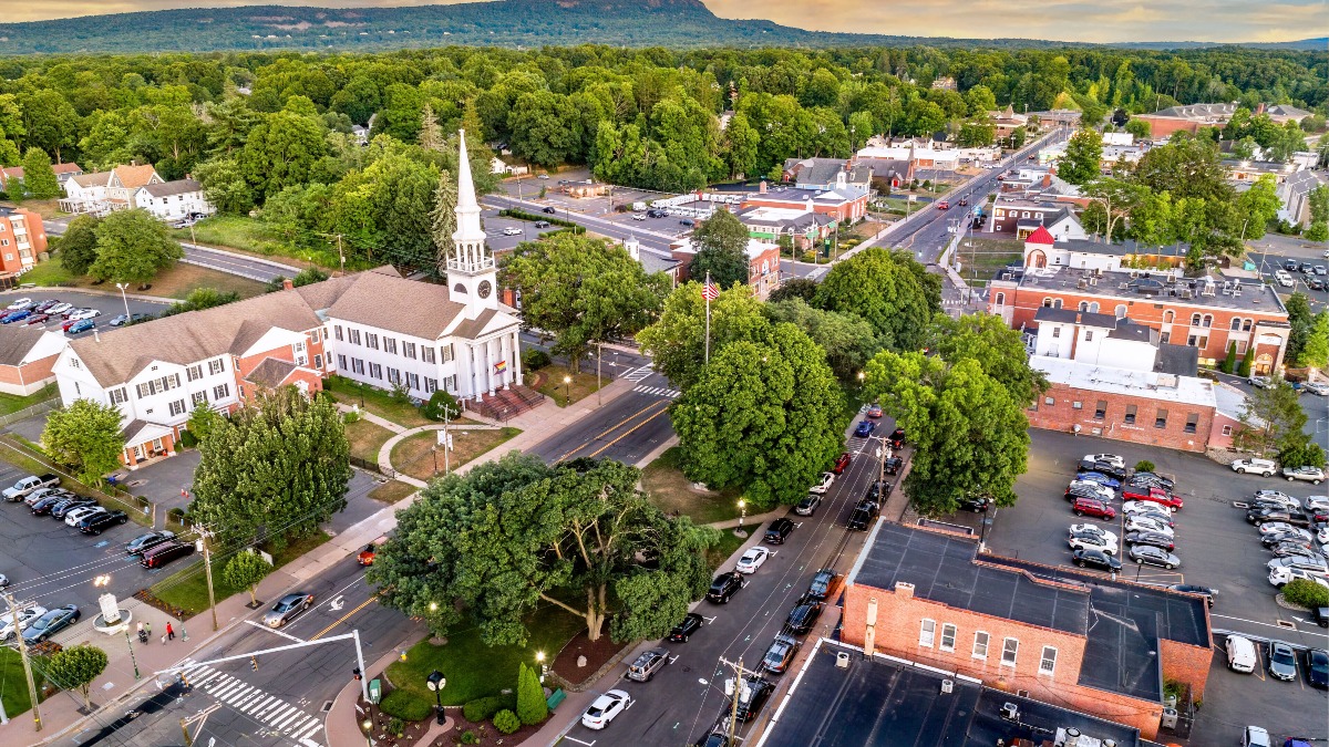A grassy field with trees and buildings in the background — Photo by Richard Liu on Unsplash